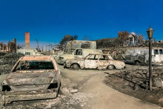 Aschgraue, verbrannte Hausreste und Autos an einer Straße nach dem mega-Waldbrand im Dezember 2017 in Kalifornien.