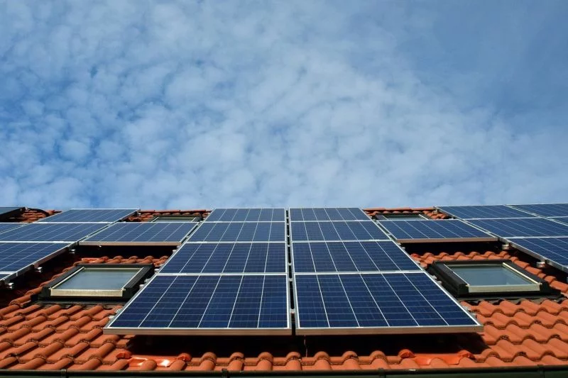 Zahlreiche Solarmodule auf einem Hausdch.
