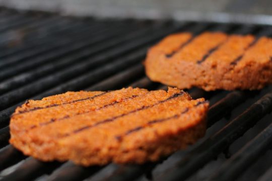 Zwei Portionen Burgerfleisch auf einem Grill.