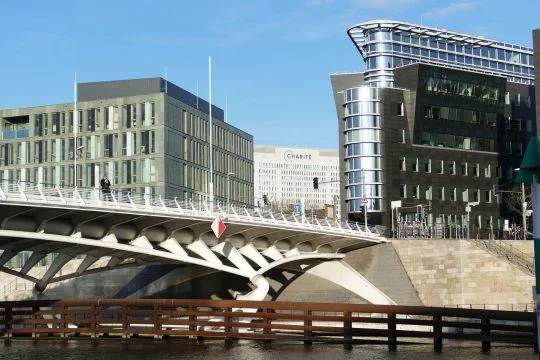 Moderne Gebäude aus Glas und Stahl in der Berliner City Ost, an einem Sommertag von einer neuen Spreebrücke aus gesehen, im Hintergrund die Charité.