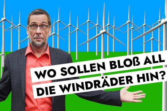Aufmacherbild: Volker Quaschning steht mit fragender Geste vor einem stilisierten Windpark.