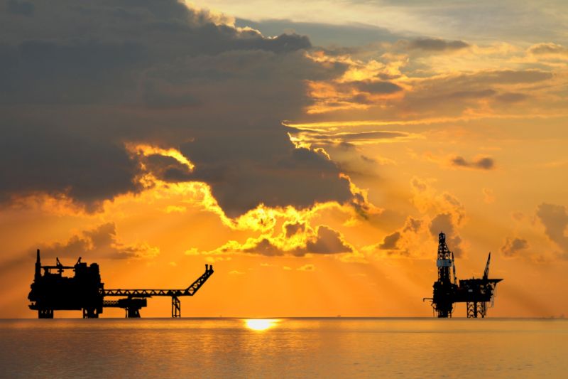 Ölförderplattformen im Meer bei Sonnenauf- oder - untergang.