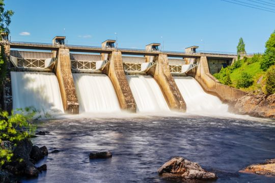 Älteres Wasserkraftwerk aus Beton mit vier Segmenten.