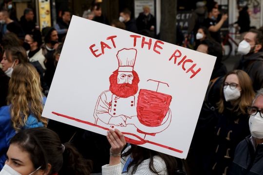 Ein handgemaltes Demo-Schild zeigt Karl Marx als Koch mit einer Sichel an einem Dönerspieß, dazu der Schriftzug: Eat the Rich.