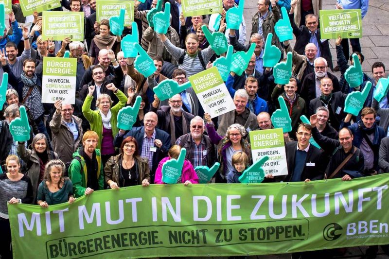 Mehrere Dutzend Energiewende-Aktivisten hinter einem Transparent: Mit Mut in die Zukunft – Bürgerenergie, nicht zu stoppen.