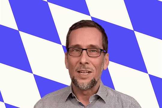Volker Quaschning - im Hintergund blau-weiße bayerische Rauten.