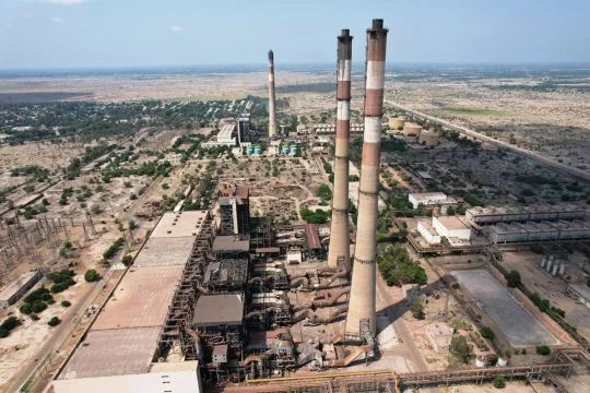 Öl- und Gas-Kraftwerk mit drei schlanken hohen Schornsteinen, bemalt mit den typischen roten und weißen Ringen.