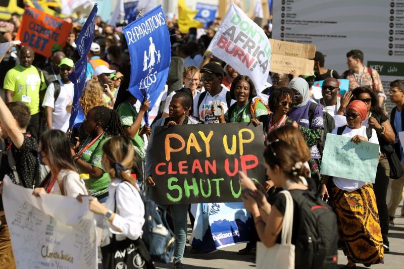 Afrikanische Frauen bei der Demonstration auf dem Klimagipfel in Sharm el-Sheikh, auf einem Transparent steht: Pay up, clean up, shut up - Bezahlen, aufräumen, Klappe halten.
