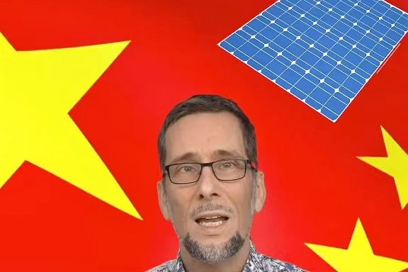 Volker Quaschning in einem chinesischen Hemd, im Hintergrund ein Solarmodul und die chinesische Flagge, rot mit gelben Sternen.