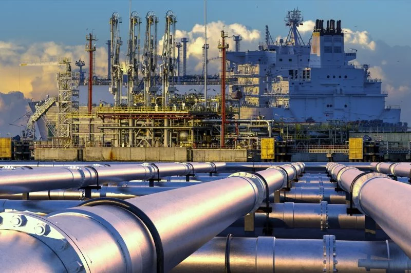 Erdgaspipelines führen zu einem LNG-Terminal, an dem ein Tankschiff liegt.