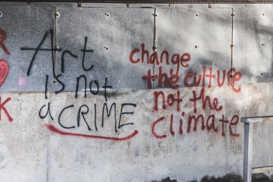 Graffito an einer Betonwand auf Englisch: Kunst ist kein Verbrechen. Ändert die Kultur, nicht das Klima.