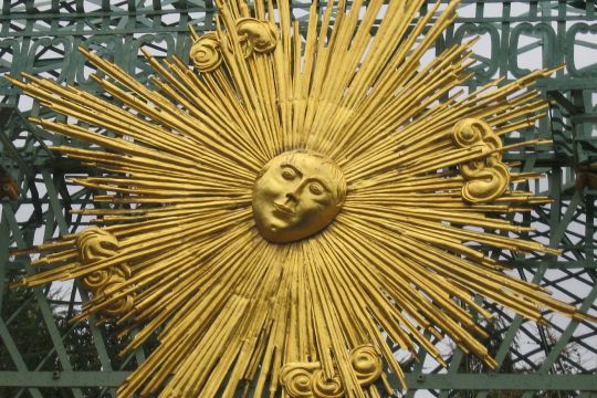Vergoldete Sonne aus Metall an einem Pavillon im Park von Schloss Sanssouci in Potsdam.