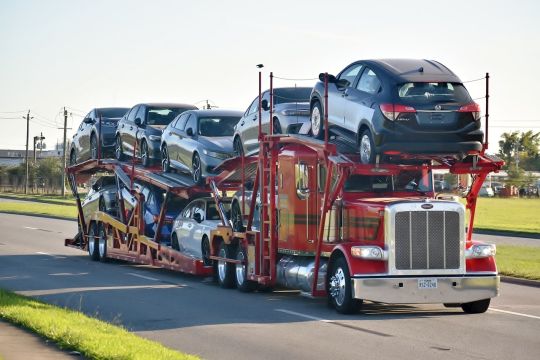 Mit Autos beladener Sattelschlepper auf einer mehrspurigen Straße in Texas.