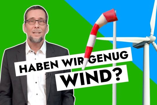 Aufmacherbild: Volker Quaschning sowie ein Windrad und ein Windsack vor einem grünen und blauen Hintergrund, dazu die Schriftzeile: Haben wir genug Wind?