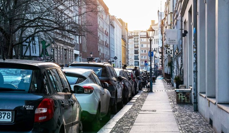 Der Straßenrand einer schmalen Wohnstraße in Berlin-Mitte ist mit Autos vollgeparkt.