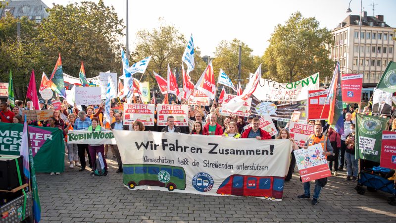 Demonstration mit Fahnen und Transparenten von Verdi, Fridays for Future und weiteren Gewerkschaften und Umweltgruppen, auf dem Fronttransparent steht: Wir fahren zusammen.
