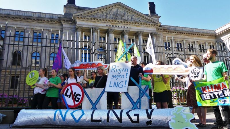 Zwei Dutzend Menschen mit bunten Schildern und Transparenten demonstrieren vor dem Bundesratsgebäude gegen LNG-Terminals auf Rügen.