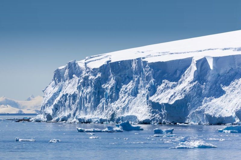 Der steil und hoch aus dem Meer aufragende Rand des Thwaites-Gletschers, von dem große Eisstücke abbröckeln.
