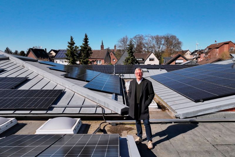 Martin Achtelik steht zwischen den Solarpaneelen auf dem Dach des Pfarrheims der Stadt Bergheim.