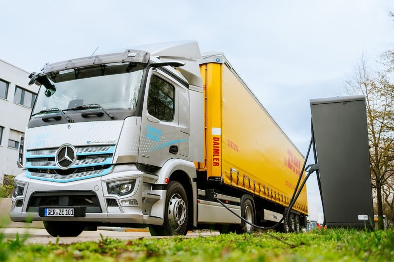 Ein Elektro-Lkw steht neben einer Ladesäule und wird aufgeladen.