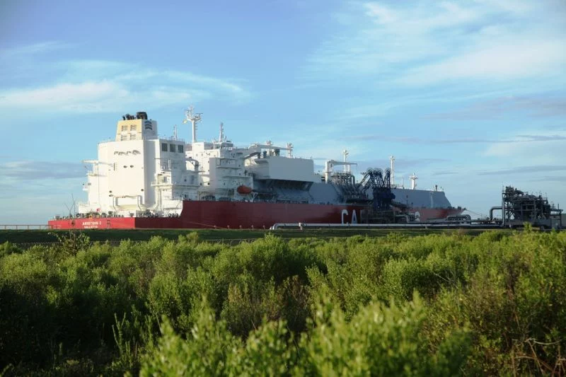 Ein Flüssigerdgas-Tanker hinter einigen Gasrohren, man sieht kein Wasser.