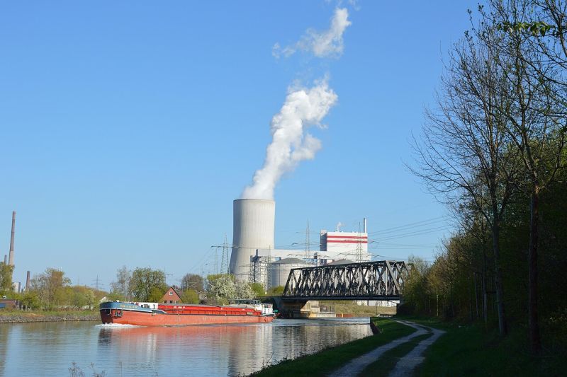 Kohlekraftwerk mit Kühlturm, daneben der Datteln-Hamm-Kanal mit einer Eisenbrücke und einem Schiff.