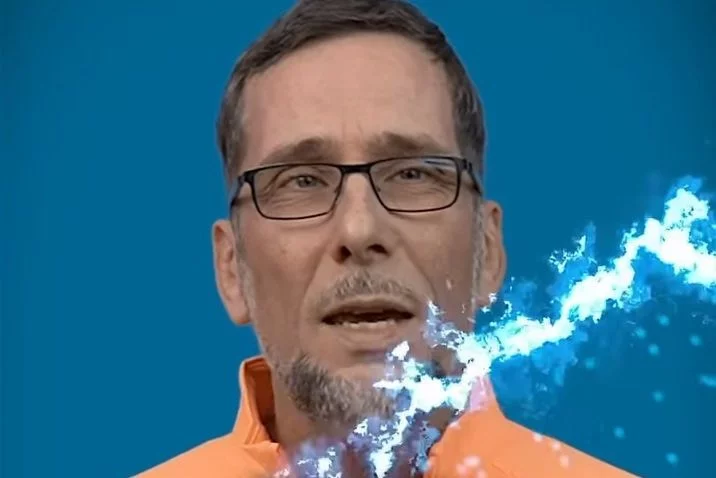 Aufmacherbild: Volker Quaschning im orangefarbenen Hemd, vor ihm ein blauer Blitz.