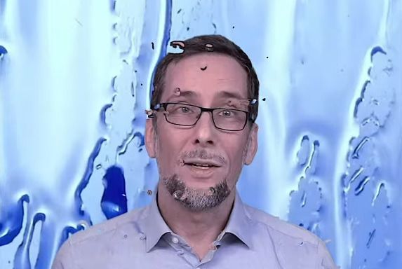 Volker Quaschning, im Hintergrund läuft eine Flüssigkeit herunter, die blauen Wasserstoff symbolisieren soll.