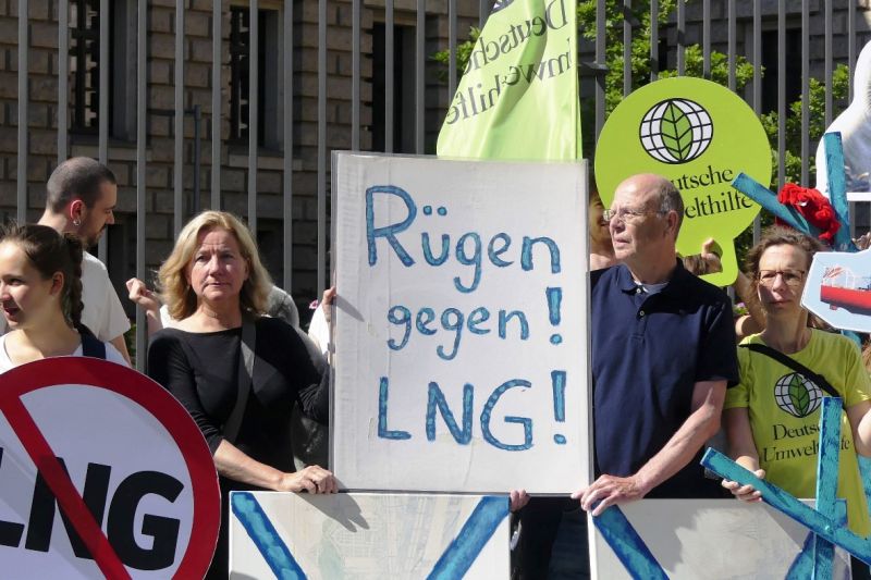 Menschen mit bunten Schildern und Transparenten demonstrieren vor dem Bundesratsgebäude gegen LNG-Terminals auf Rügen.