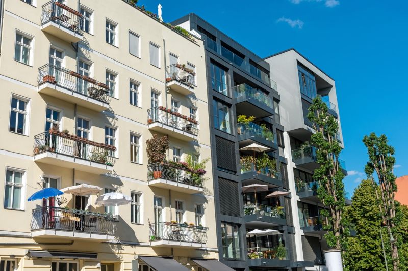 Ein mehrstöckiger Altbau und daneben ein modernes Haus, beide mit Balkons, im Berliner Stadtteil Prenzlauer Berg.