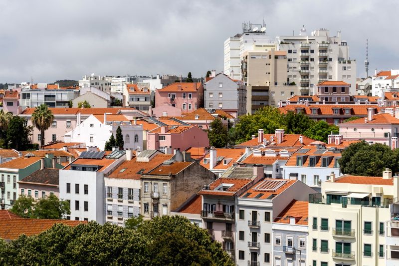 Blick auf ein Viertel von Lissabon mit vielen Mehrfamilienhäusern, auf einigen wenigen Häusern sind Solaranlagen.