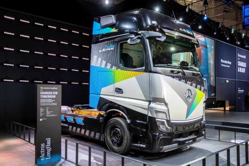 Ein batteriebetriebener Sattelschlepper von Mercedes wird in einer Messehalle präsentiert, Menschen sind keine zu sehen.