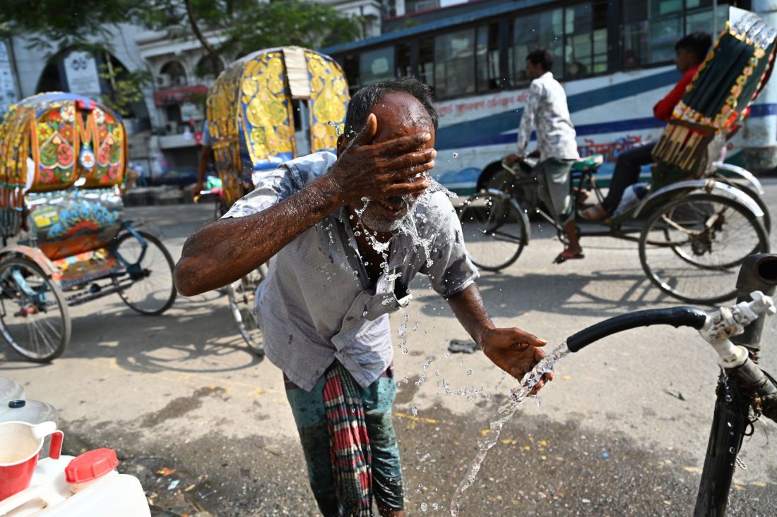Ein Mann erfrischt sich an einer Wasserleitung am Straßenrand bei hohen Temperaturen in Dhaka, der Hauptstadt von Bangladesch.