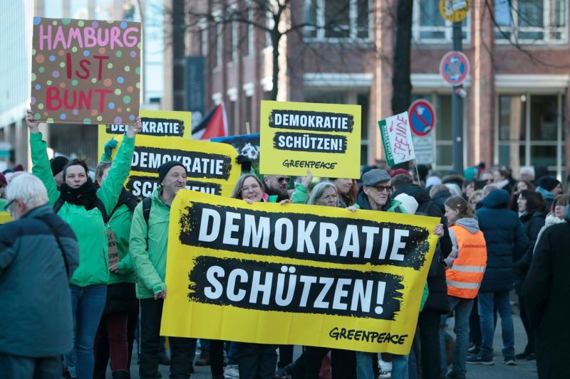 Greenpeace-Mitglieder demonstrieren in Hamburg mit Transparenten: Demokratie schützen!